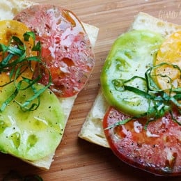 A juicy open faced summer tomato sandwich on crusty bread drizzled with extra virgin olive oil, a chiffonade of fresh basil, salt and fresh ground pepper. Simplicity at it's best!