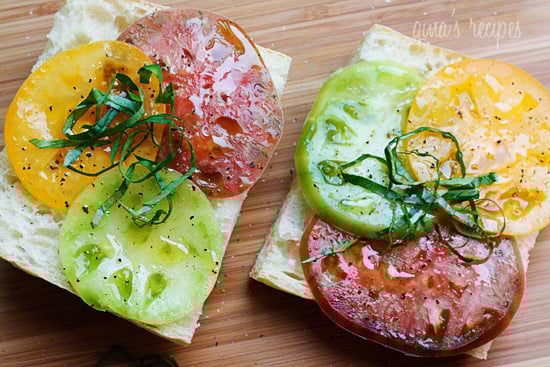 A juicy open faced summer tomato sandwich on crusty bread drizzled with extra virgin olive oil, a chiffonade of fresh basil, salt and fresh ground pepper. Simplicity at it's best!