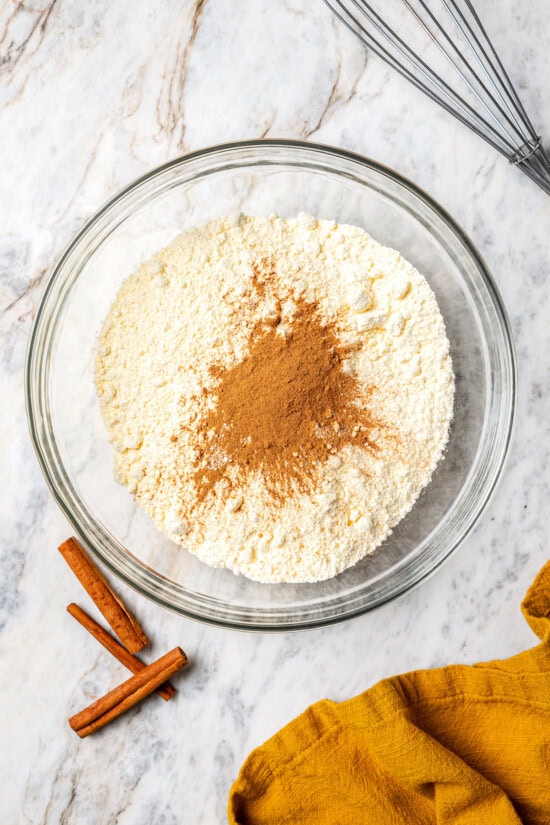 Boxed cake mix makes these pumpkin cupcakes easy to whip up for Halloween parties, Thanksgiving or anytime you want a cozy fall treat! Overhead view of pumpkin spice added to cake mix