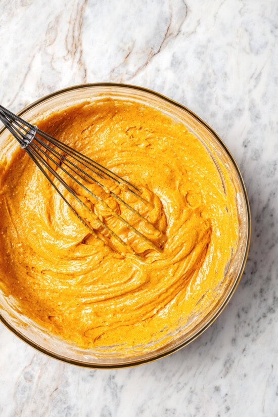 Boxed cake mix makes these pumpkin cupcakes easy to whip up for Halloween parties, Thanksgiving or anytime you want a cozy fall treat! Overhead view of pumpkin cupcake batter in bowl