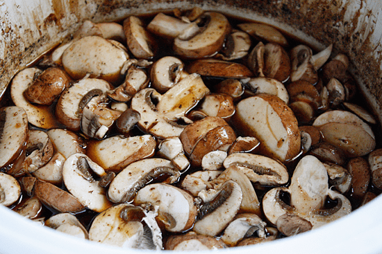 Boneless pork roast slow cooked in Asian spices creates a aromatic pork dish with mushrooms and broth, perfect over noodles or rice with fresh chopped green onions, cilantro and sriracha.