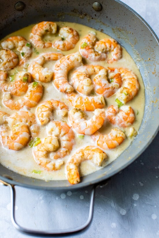 Skillet with shrimp, coconut milk and green curry paste.