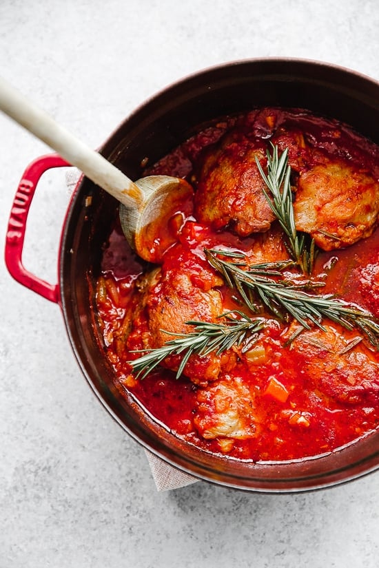Pollo in Potacchio is an Italian braised chicken dish made with tomatoes, rosemary and garlic. The chicken cooks until it's fork tender, which is great served with pasta, noodles or polenta.