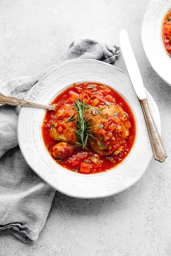 Pollo in Potacchio is an Italian braised chicken dish made with tomatoes, rosemary and garlic. The chicken cooks until it's fork tender, which is great served with pasta, noodles or polenta.