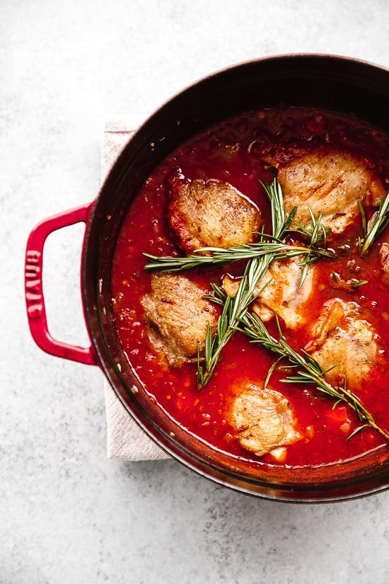 Pollo in Potacchio is an Italian braised chicken dish made with tomatoes, rosemary and garlic. The chicken cooks until it's fork tender, which is great served with pasta, noodles or polenta.