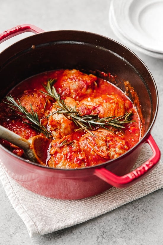 Pollo in Potacchio is an Italian braised chicken dish made with tomatoes, rosemary and garlic. The chicken cooks until it's fork tender, which is great served with pasta, noodles or polenta.