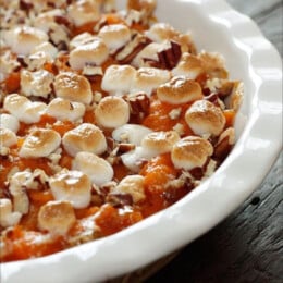 A sweet potato casserole with marshmallows in a round baking dish.