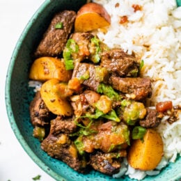 Carne Guisada or Latin Beef Stew is made with chunks of beef simmered in beer with scallions, garlic, tomatoes, cumin and cilantro.