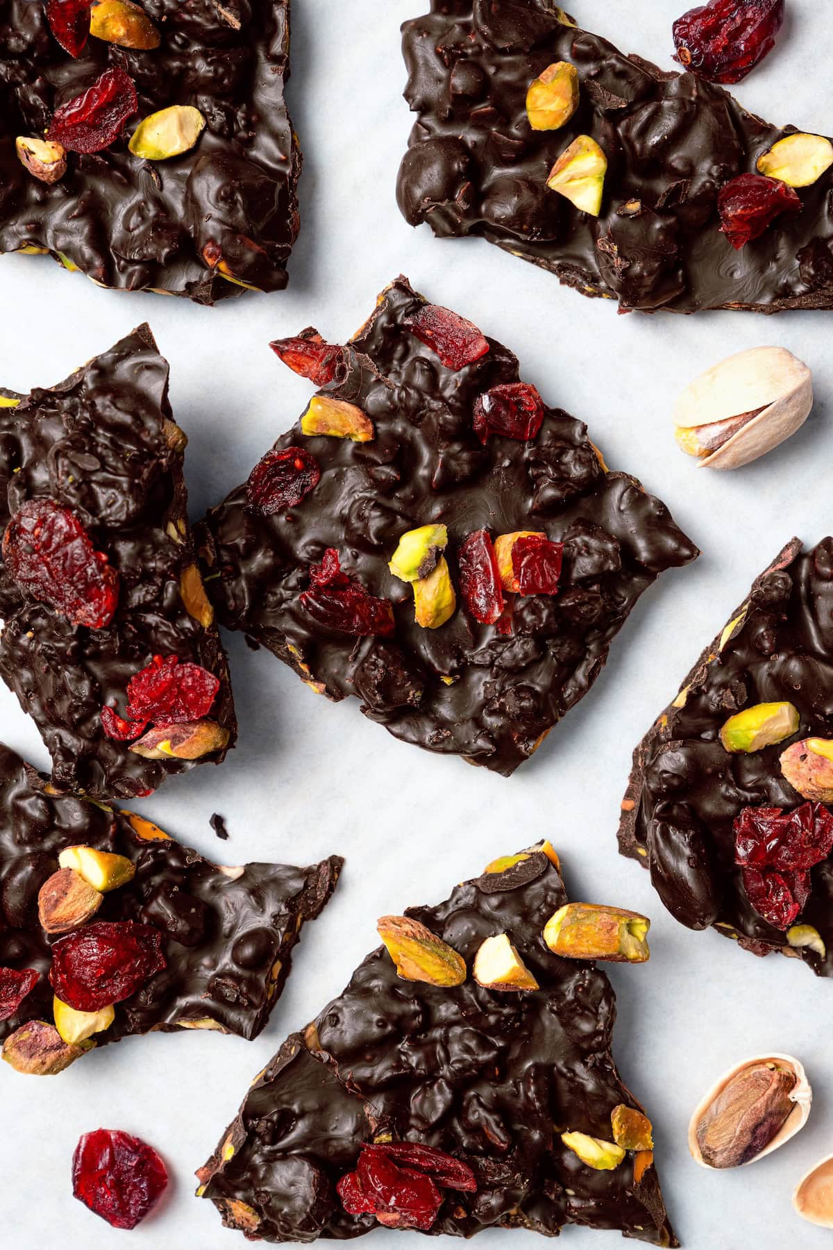This easy Dark Chocolate Bark with Pistachios and Cranberries is festive enough for a holiday treat, but healthy enough to enjoy year round! Pistachio and cranberry dark chocolate bark on countertop.
