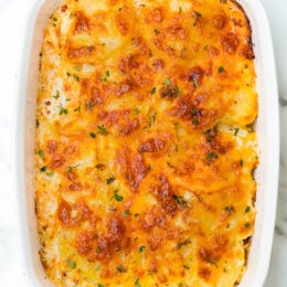 A delicious Scalloped Potato Gratin recipe made with thinly sliced Yukon gold potatoes layered with cheese and a light buttery sauce.