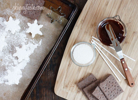 Smores Pops – Chocolate graham crackers coated with melted chocolate and marshmallows on a stick. A fabulous winter treat whether you want to make them as favors or just have fun making them with the kids.