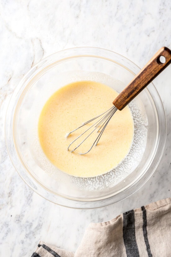 Chocolate chip scones are sweetened to perfection and studded with chocolate chips to make them taste like a treat. An easy no-fail recipe! Liquid ingredients for scones in bowl with whisk