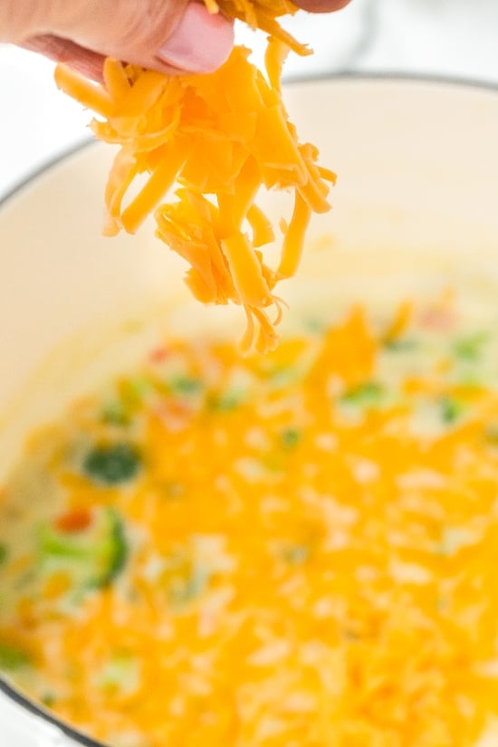 making soup with shredded cheddar.