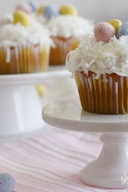 A quick and easy coconut cupcake made with a box white cake mix, light coconut milk and apple sauce. No butter, no oil necessary for this lower calorie cupcake recipe! Sweetened coconut flakes are combined with a light cream cheese frosting for a divine finish!