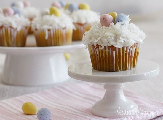 A quick and easy coconut cupcake made with a box white cake mix, light coconut milk and apple sauce. No butter, no oil necessary for this lower calorie cupcake recipe! Sweetened coconut flakes are combined with a light cream cheese frosting for a divine finish!