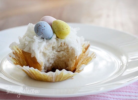 A quick and easy coconut cupcake made with a box white cake mix, light coconut milk and apple sauce. No butter, no oil necessary for this lower calorie cupcake recipe! Sweetened coconut flakes are combined with a light cream cheese frosting for a divine finish!