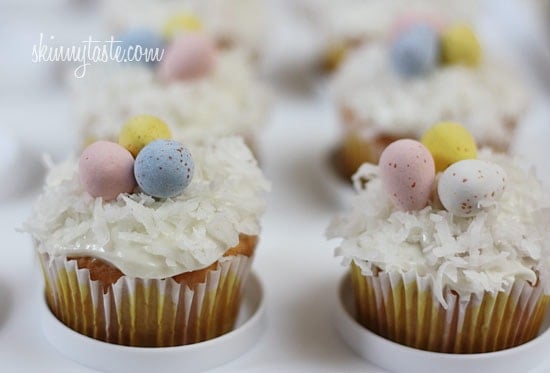 A quick and easy coconut cupcake made with a box white cake mix, light coconut milk and apple sauce. No butter, no oil necessary for this lower calorie cupcake recipe! Sweetened coconut flakes are combined with a light cream cheese frosting for a divine finish!
