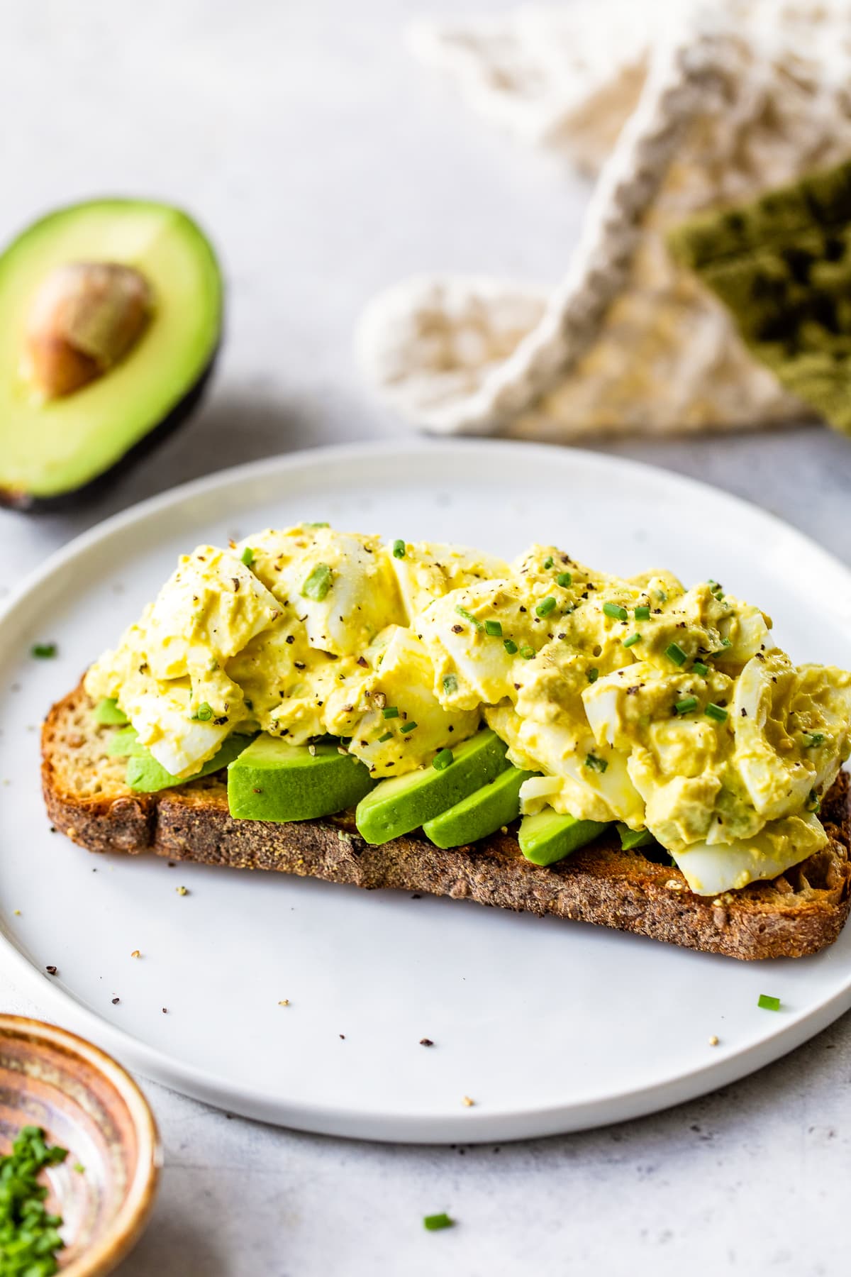This avocado egg salad uses half the egg yolks and adds lots of healthy fats from avocado. An easy healthy, high protein lunch! Avocado Egg Salad on a piece of toast.