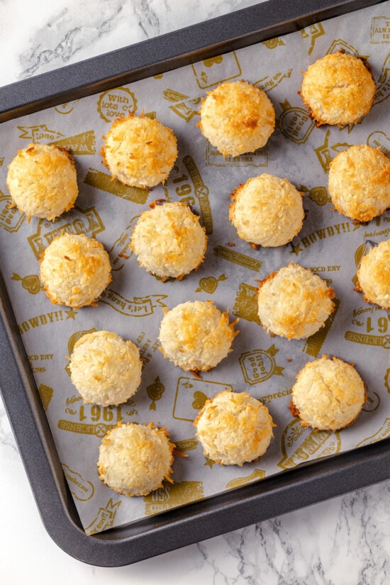Made with sweetened coconut flakes, egg whites, and just a few other ingredients, Coconut Macaroons are moist, chewy, and perfectly flavored. Baked coconut macaroons on a baking sheet