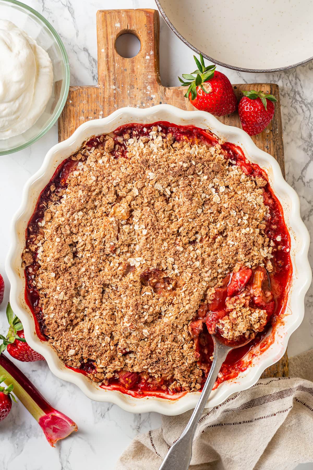 Honey adds the perfect amount of sweetness to the filling in this strawberry rhubarb crisp recipe. Easy to make and impossible to resist! Overhead view of strawberry rhubarb crisp in baking dish with spoon