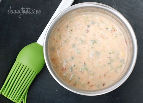A bowl of creamy chili sauce with a silicone brush next to it