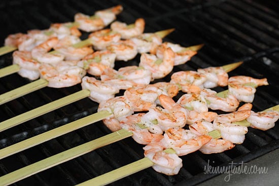 Skewers of shrimp cooking on a grill