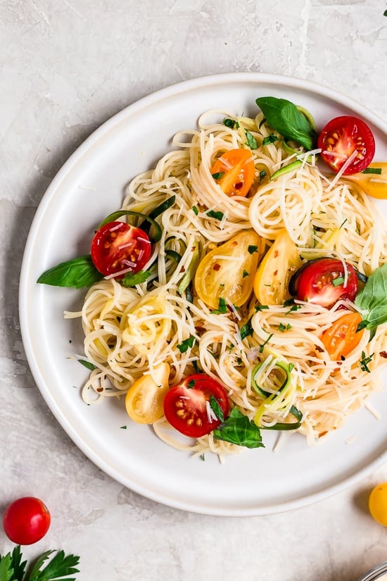 Angel hair pasta tossed with summer zucchini and tomatoes fresh from the garden. The perfect meatless meal you'll be craving again and again. Serve this with plenty of Parmigiano Reggiano!