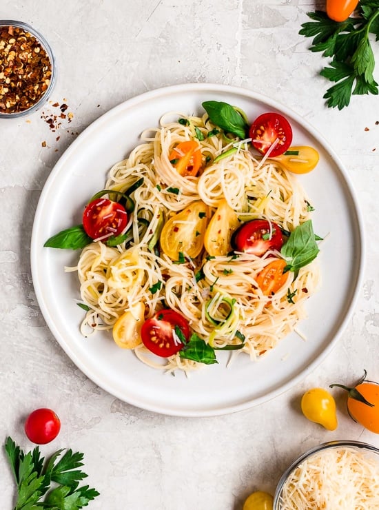 Angel hair pasta tossed with summer zucchini and tomatoes fresh from the garden. The perfect meatless meal you'll be craving again and again. Serve this with plenty of Parmigiano Reggiano!
