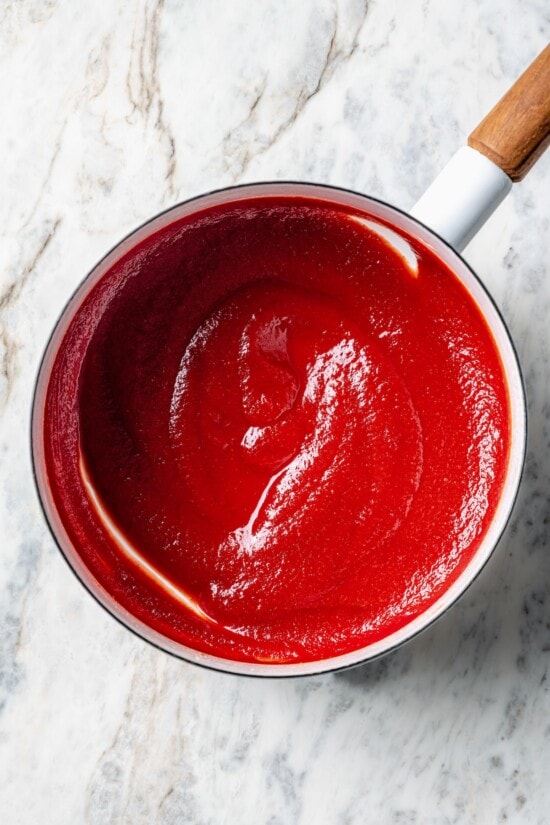 A healthy recipe for homemade ketchup with no high fructose corn syrup. Instead it's sweetened naturally with honey and it tastes amazing! Overhead view of homemade ketchup in saucepan