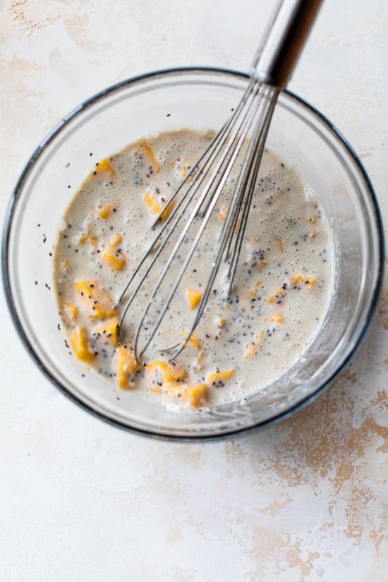 This Mango Coconut Chia Pudding is made with coconut milk, chia seeds, shredded coconut, and mango. An easy, feel-good recipe! Ingredients for coconut chia pudding being mixed in a bowl.