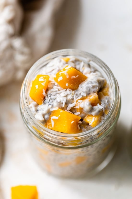 This Mango Coconut Chia Pudding is made with coconut milk, chia seeds, shredded coconut, and mango. An easy, feel-good recipe! A mason jar filled with coconut chia pudding topped with mango.