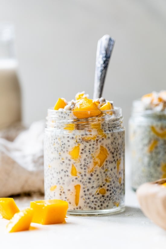 Mango Coconut Chia Pudding in a mason jar with a spoon.