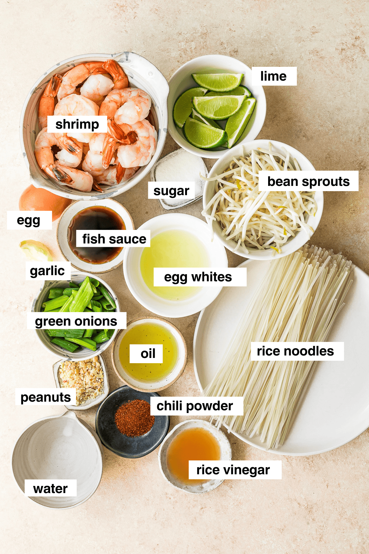 This easy homemade Pad Thai recipe is a lightened up version of the original made with shrimp, eggs, and tofu. Dinner’s done in 25 minutes! Overhead view of Pad Thai ingredients with labels