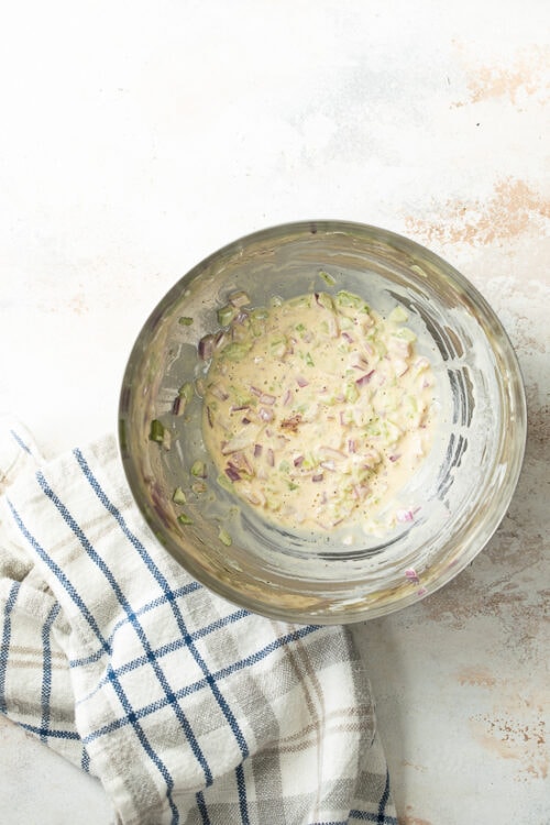 While the potatoes are boiling, combine red onion, celery, mustard, olive oil, vinegar and mayonnaise and season with salt and pepper.