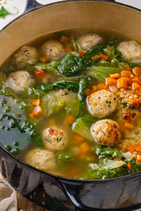 Made with homemade turkey meatballs, tiny pasta, and dark leafy greens, Italian Wedding Soup is simple yet flavorful. Ready in 30 minutes! Italian wedding soup in a pot