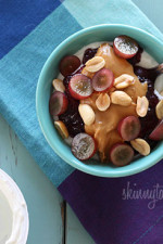 Peanut butter, grape jam, peanuts, and fresh red grapes on top of a bowl of yogurt... who needs the bread!