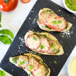 This easy Baked Pesto Chicken is a fast chicken dish made with skinless chicken breasts, pesto, tomatoes, mozzarella and Parmesan cheese. You can make this in the oven, or make it outside on the grill!
