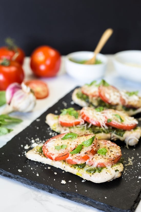 Chicken Pesto Bake is a simple, light dish made with skinless chicken breasts, pesto, tomatoes, mozzarella and Parmesan cheese. You can make this in the oven, or make it outside on the grill!