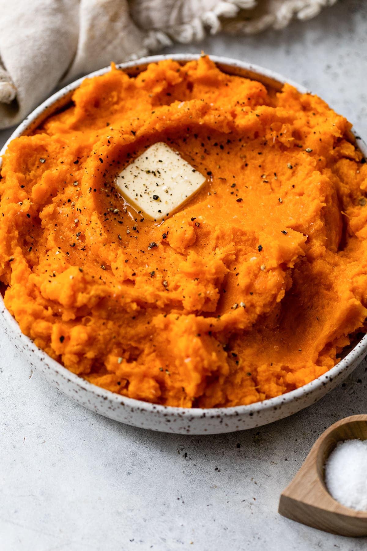 These buttery mashed sweet potatoes are a fluffy, creamy, and delicious side dish recipe. Ready in 25 minutes and made without sugar! Mashed sweet potatoes topped with a pat of butter in a bowl with a spoon.