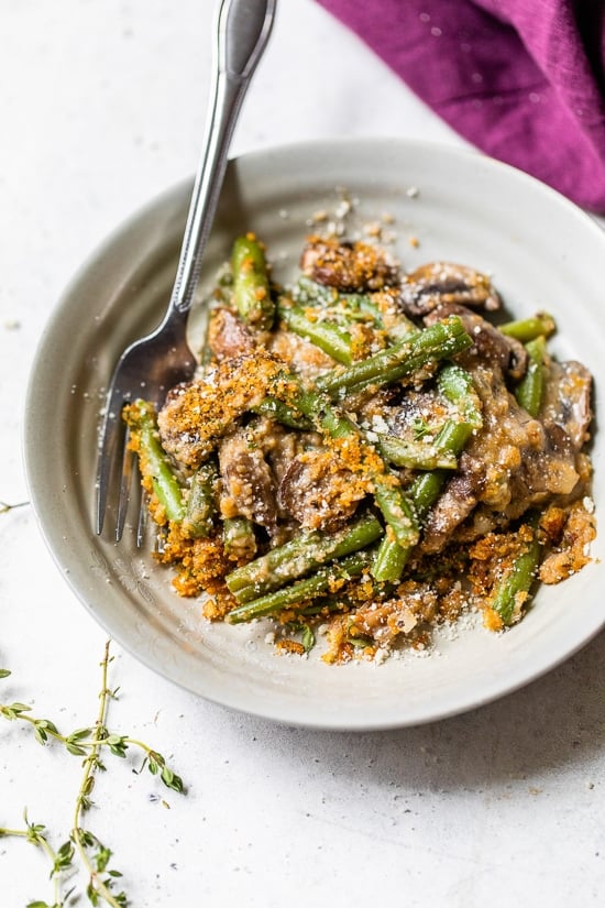This Green Bean Casserole From Scratch features fresh green beans, cremini mushrooms, shallots, and grated parmesan. Green Beans on a plate.