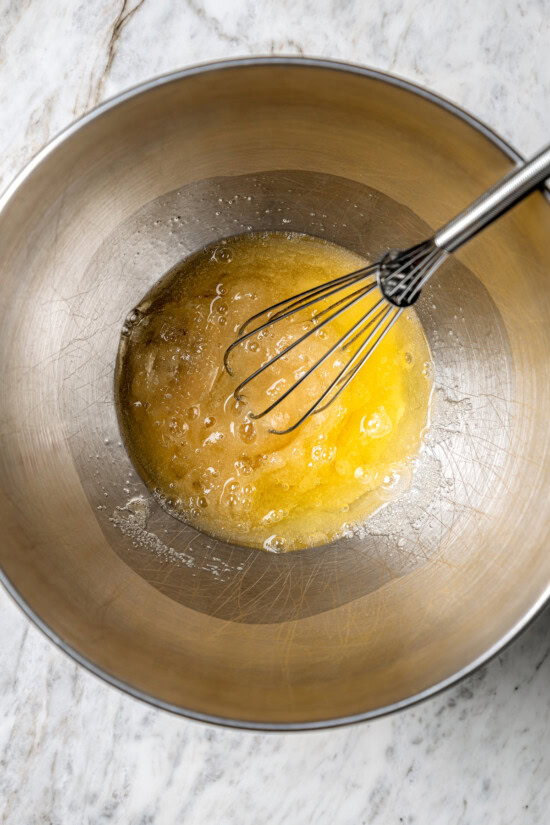 Light and airy peppermint meringues are the perfect addition to any holiday cookie tray! They're surprisingly easy to make and always a hit. Whisking egg and sugar in bowl on stove