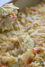 Hot and cheesy imitation crab and artichoke dip is to die for! Serve this glorious dip with baked chips and you will have the perfect appetizer for any party.