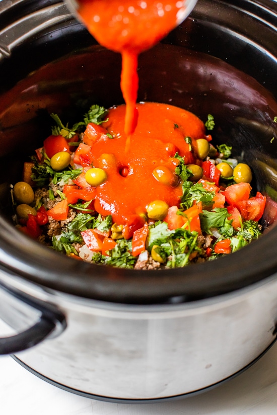 Crock Pot Picadillo is a flavorful Cuban dish made with ground beef and a sauce made from simmering tomatoes, green olives, bell peppers, cumin, and spices.