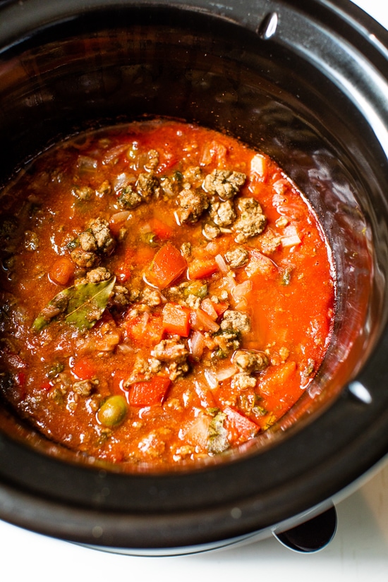 Crock Pot Picadillo is a flavorful Cuban dish made with ground beef and a sauce made from simmering tomatoes, green olives, bell peppers, cumin, and spices.
