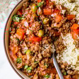Crock Pot Picadillo is a flavorful Cuban dish made with ground beef and a sauce made from simmering tomatoes, green olives, bell peppers, cumin, and spices.