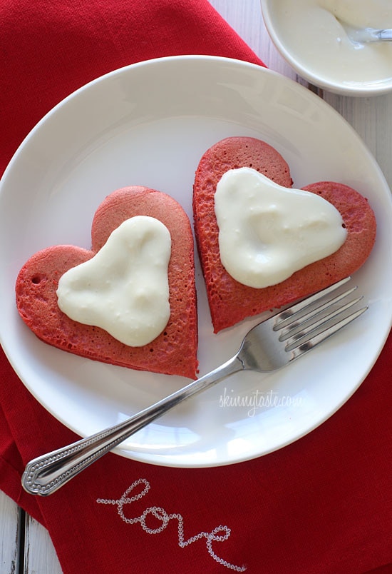 These lightened-up red velvet pancakes are made with a blend of white whole wheat flour and all purpose, then topped with a light cream cheese topping.  I adore red velvet, so I can't think of a more fitting time to make red velvet pancakes, then for Valentine's Day!