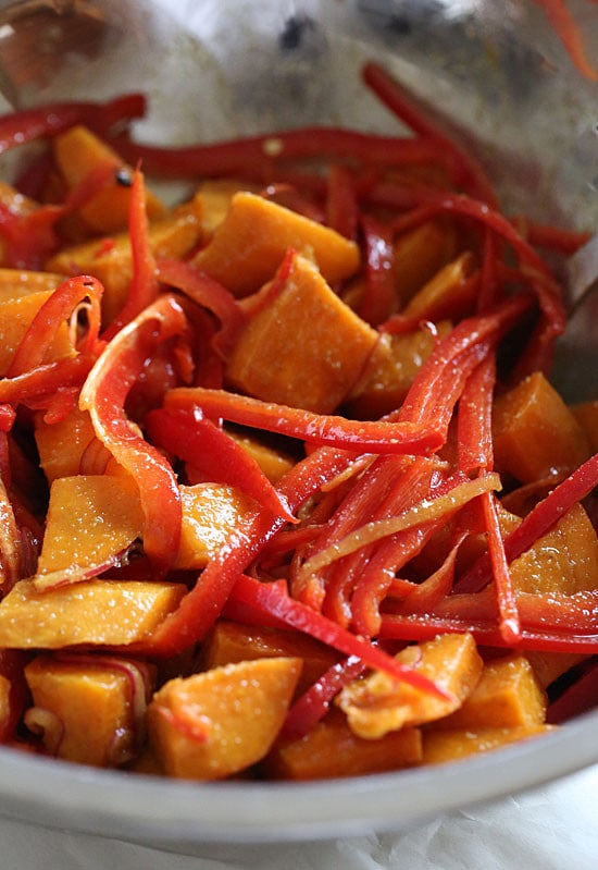 Kumara tandoori salad made of roasted sweet potatoes, seasoned with curry and spices, then tossed with bell peppers, baby spinach and a flavorful vinaigrette.