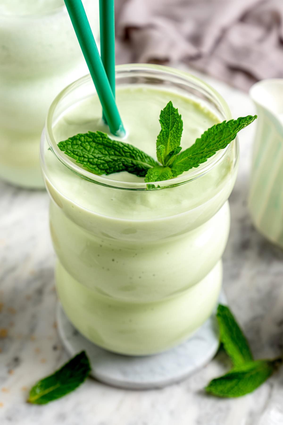 This easy homemade shamrock shake recipe is thick, creamy, and minty just like the original—with a fraction of the calories! Copycat shamrock shake in glass with mint leaves for garnish