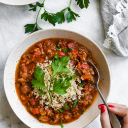 Hand digging into bowl of stuffed pepper soup
