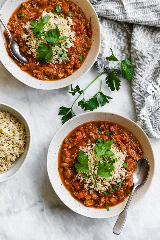 This easy stuffed pepper soup has bell peppers, ground beef, tomatoes, and rice in a hearty bowl of soup. Stovetop and Instant Pot options! Two bowls of stuffed pepper soup with rice